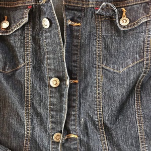 May include: A dark blue denim jacket with a button closure and two front pockets.