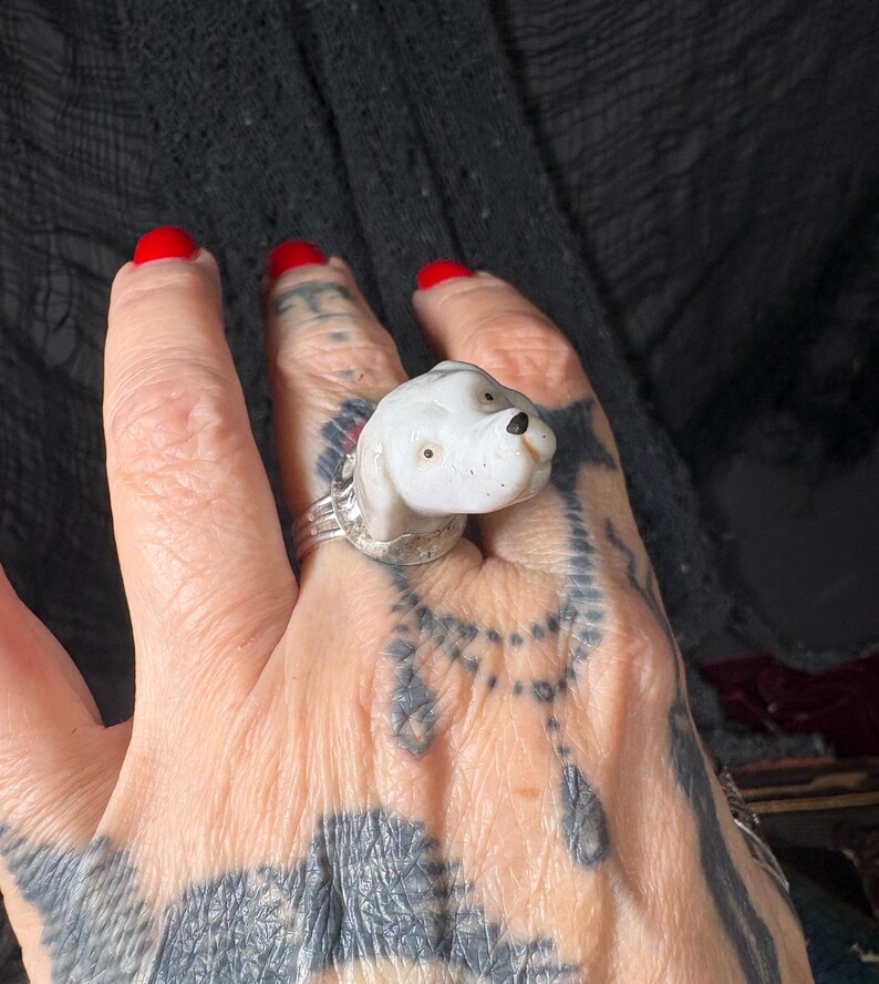 Peut inclure: Bague en c&eacute;ramique blanche repr&eacute;sentant un chien, avec un anneau argent&eacute;. Le chien a les yeux marron et un nez noir. Un bijou unique.