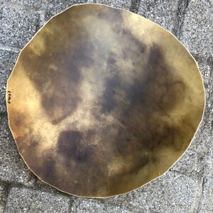 May include: A large, round, brass tray with a hammered finish. The tray has a slightly irregular shape and a warm, golden color.