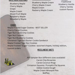 May include: A menu list featuring Maple Cream Filled Rings, Maple Cream Sandwiches, Waffles, Cookies, and Miscellaneous Sweets. The text includes various flavors like Blueberry Maple, Cherry Carob, and Tiger Nut. A small yellow bee icon is visible.