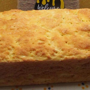 May include: A loaf of freshly baked bread in a blue and white ceramic baking dish. The bread is golden brown and has a slightly crusty exterior.