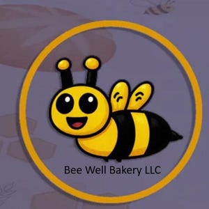 May include: A circular logo featuring a cartoon bee with a yellow and black striped body, large black eyes, and a smiling mouth. The bee is enclosed within a thick yellow ring. Below the bee, the text Bee Well Bakery LLC is printed in black.