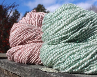 May include: Two skeins of yarn, one pink with white flecks and one green with white flecks.