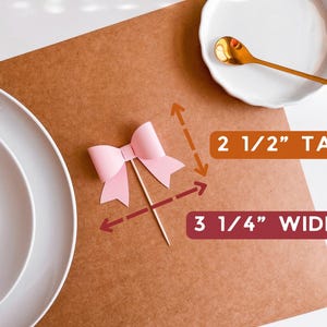 Op de afbeelding: Roze strik cake topper met een houten stokje. De strik is 2 1/2 inch hoog en 3 1/4 inch breed.