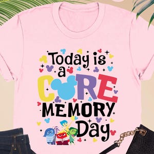 May include: Pink t-shirt with the text "Today is a CORE MEMORY Day" and a cartoon image of Mickey Mouse ears and the characters from the movie Inside Out.
