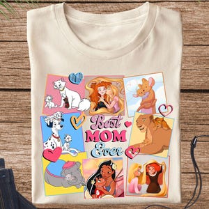 Pode incluir: Uma camiseta bege com uma colagem de personagens de desenhos animados e o texto "Best Mom Ever". Os personagens incluem um d&aacute;lmata, um le&atilde;o, um gato e uma princesa.