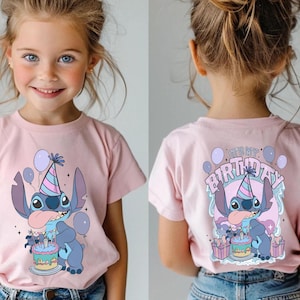 May include: A pink t-shirt with a cartoon character design, including a party hat, cake, and balloons. The front of the shirt shows the character, and the back says "It's My Birthday". The t-shirt is worn by a young girl.