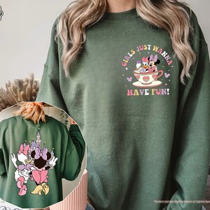 a woman wearing a green sweatshirt with an image of minnie mouse on it