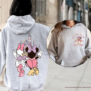 a woman wearing a mickey mouse hoodie on the street