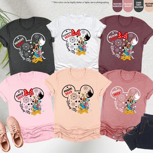 May include: Six t-shirts with a Mickey Mouse ear design featuring a family of Disney characters. Each shirt has a different name and the year 2025. The shirts are in various colors including heather grey, white, maroon, peach, pink, and light orange.
