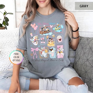 May include: Gray t-shirt featuring colorful Disney character illustrations. The design includes Mickey and Minnie Mouse, Donald Duck, Dumbo, and other characters. Text on the shirt reads "The Most Magical Place on Earth."