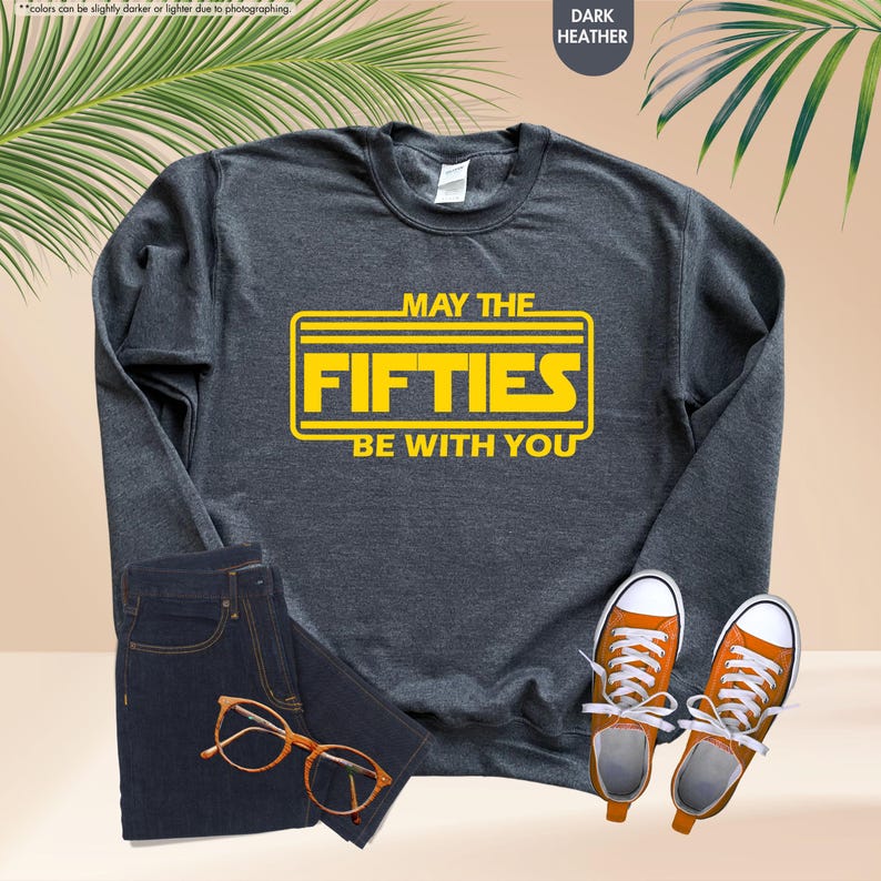 May include: A dark heather grey sweatshirt with a yellow graphic that says "May the Fifties Be With You".