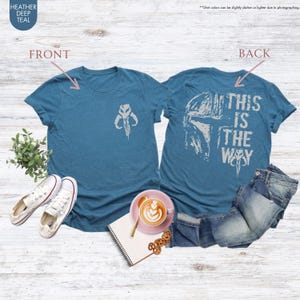 Pu&ograve; includere: Una maglietta blu con un simbolo mandaloriano bianco sul davanti e il testo "This is the way" con una grafica di casco mandaloriano bianco sul retro.