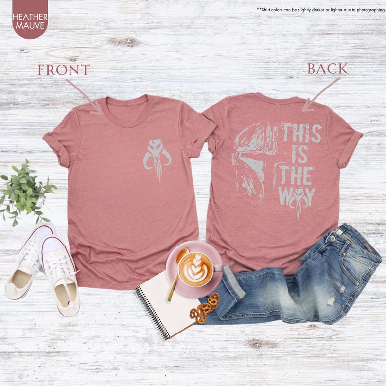 Pu&ograve; includere: Una t-shirt color malva melange con un simbolo mandaloriano sul davanti e il testo "This is the way" con un elmetto mandaloriano sul retro.