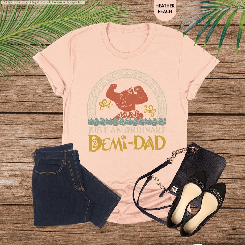 Puede incluir: Una camiseta rosa con un personaje de dibujos animados y el texto "Just an ordinary Demi-Dad".