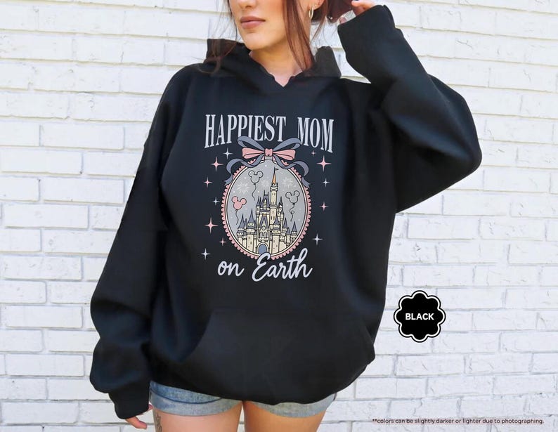 May include: Black hooded sweatshirt with the text "HAPPIEST MOM on Earth" in a decorative font. The design includes a castle, bow, and stars. The word "BLACK" is in a black bubble.
