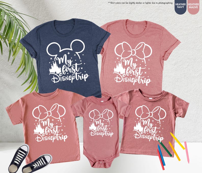 Pode incluir: Conjunto de quatro t-shirts com um gr&aacute;fico branco de orelhas do Mickey Mouse e um castelo com o texto "My first Disneptrip". As t-shirts s&atilde;o em azul marinho heather, malva heather e dois tamanhos diferentes de malva heather.