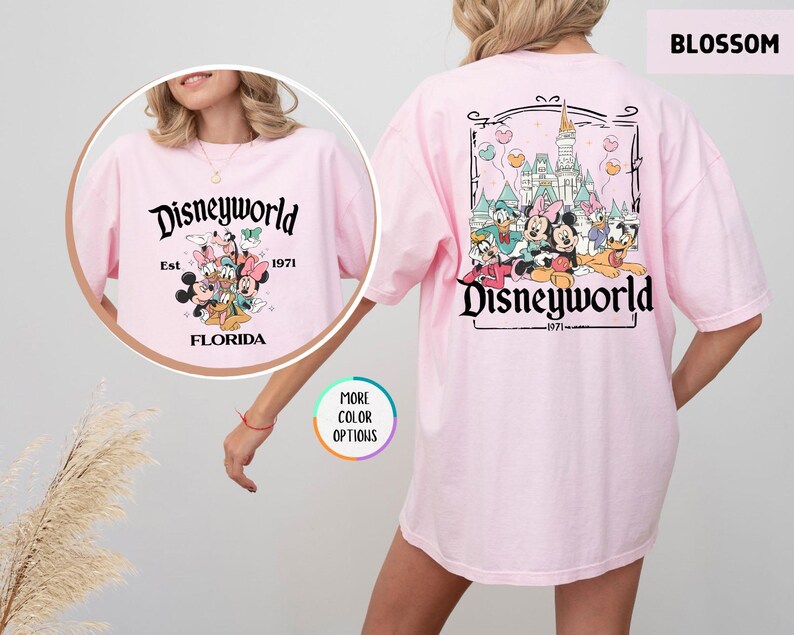Puede incluir: Camiseta rosa claro con un dise&ntilde;o de Disneyworld. La parte delantera presenta el texto "Disneyworld Est. 1971 Florida" con Mickey, Minnie, Donald y Goofy. La parte trasera tiene un castillo y el texto "Disneyworld 1971".