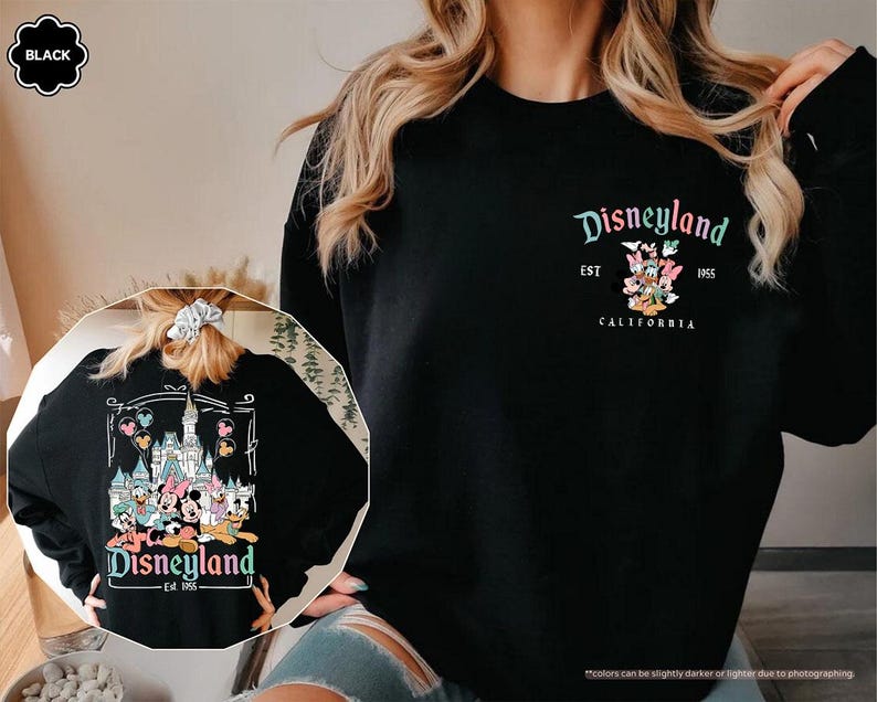 May include: Black sweatshirt with a white graphic print of Mickey Mouse characters in front of the Disneyland castle. The text "Disneyland Est 1955 California" is printed below the graphic.