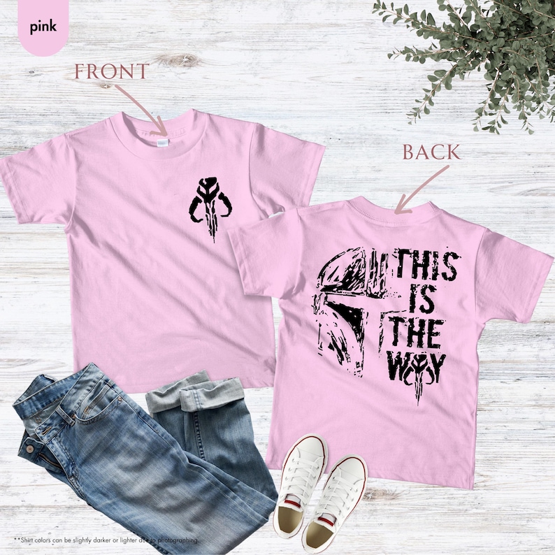 Pu&ograve; includere: Maglietta rosa con una grafica nera di un elmetto mandaloriano sul retro e un simbolo nero sul davanti. Il testo "This is the Way" &egrave; stampato sul retro della maglietta.