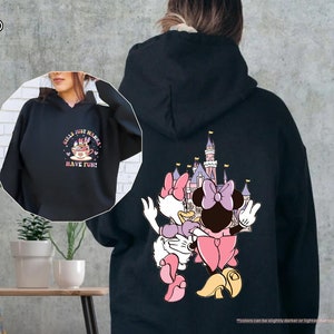 a woman wearing a black hoodie with an image of a cartoon character on it