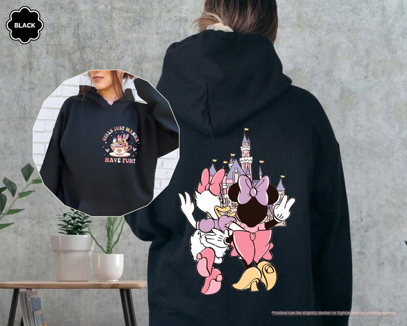 a woman wearing a black hoodie with an image of a cartoon character on it