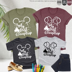 Pode incluir: Quatro camisetas com o texto "My first Disneptrip" em branco. As camisetas s&atilde;o de cores diferentes: verde, vinho, cinza e cinza escuro. Cada camiseta tem um design diferente: orelhas do Mickey Mouse, orelhas da Minnie Mouse e um castelo.