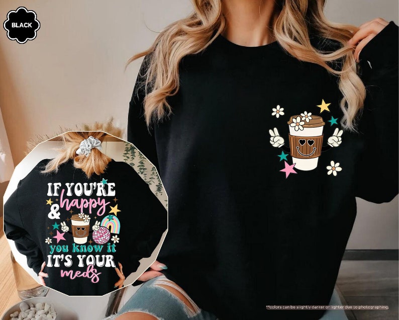 a woman wearing a black sweatshirt with a cup of coffee on it