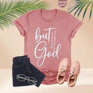 a t - shirt with the words but god on it next to a pair of