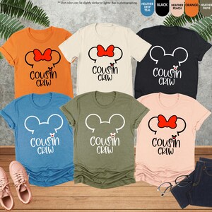 以下が含まれることがあります： ミッキーマウスの頭の白い輪郭と「Cousin Crew」という文字が印刷された、異なる色のTシャツ6枚。ミッキーマウスの頭には赤いリボンと赤い鼻がついています。