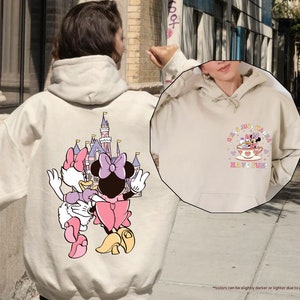 a person wearing a mickey mouse hoodie on a city street