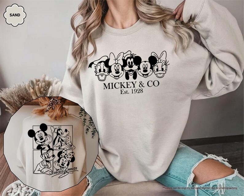 Pu&ograve; includere: Felpa color sabbia con grafica nera di Topolino, Minnie, Paperino e Paperina. Il testo "MICKEY & CO Est. 1928" &egrave; stampato sotto i personaggi. &Egrave; visibile anche un'immagine pi&ugrave; piccola di Topolino e dei suoi amici.