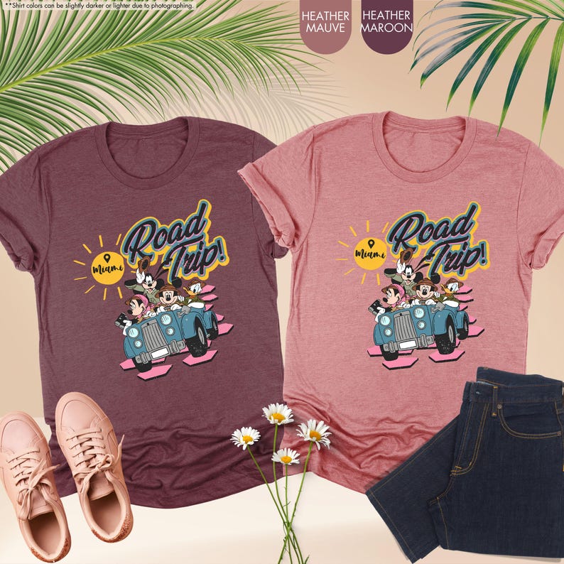 Op de afbeelding: Twee heather t-shirts, &eacute;&eacute;n mauve en &eacute;&eacute;n bordeauxrood, met een "Road Trip! Miami"-afbeelding met stripfiguren in een vintage auto. De shirts worden gecombineerd met een jeans en sneakers.