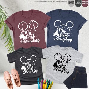 Pode incluir: Quatro camisetas com o texto "My first Disneptrip" em branco. As camisetas s&atilde;o de diferentes cores: vinho, azul marinho, cinza escuro e cinza claro. Cada camiseta tem um gr&aacute;fico branco de orelhas do Mickey Mouse ou orelhas da Minnie Mouse com um la&ccedil;o.