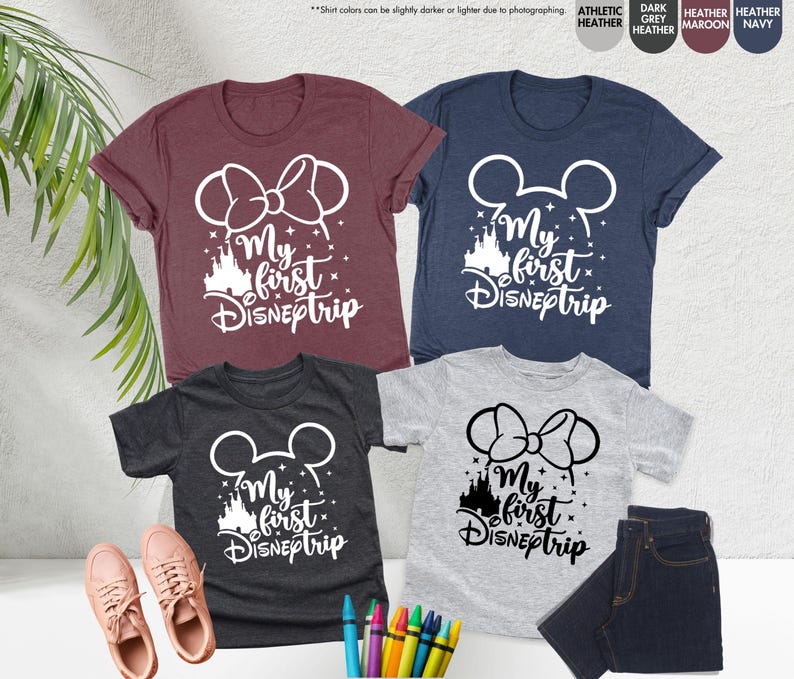 Pode incluir: Quatro camisetas com o texto "My first Disneptrip" em branco. As camisetas s&atilde;o de diferentes cores: vinho, azul marinho, cinza escuro e cinza claro. Cada camiseta tem um gr&aacute;fico branco de orelhas do Mickey Mouse ou orelhas da Minnie Mouse com um la&ccedil;o.