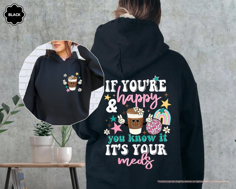a woman wearing a black hoodie with a picture of a cup of coffee on