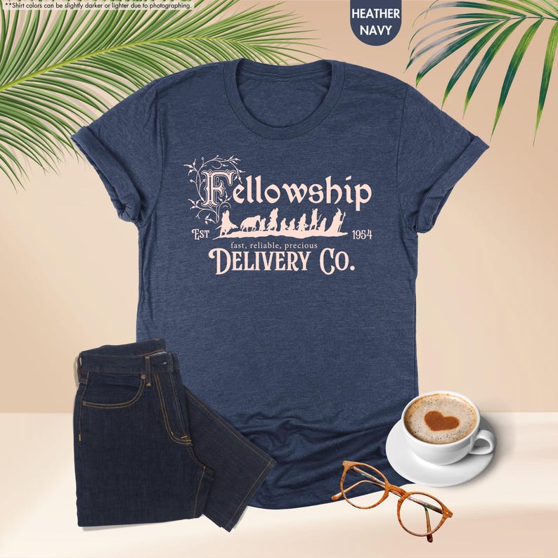 Puede incluir: Una camiseta azul marino jaspeada con un dise&ntilde;o gr&aacute;fico rosa que dice "Fellowship Est. 1954 fast, reliable, precious DELIVERY CO."
