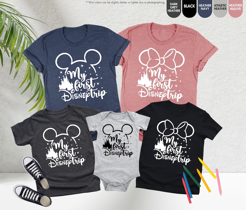 Pode incluir: Um conjunto de quatro t-shirts com uma silhueta branca de orelhas do Mickey Mouse e o texto "My first Disneptrip". As t-shirts s&atilde;o de diferentes cores: cinza escuro mesclado, cinza claro, preto e rosa.
