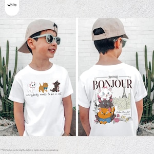 May include: White t-shirt featuring cartoon cats with the text "everybody wants to be a cat" on the front. The back of the shirt has the word "Bonjour" and the text "Aristocats" with a picture of the Eiffel Tower and more cartoon cats.