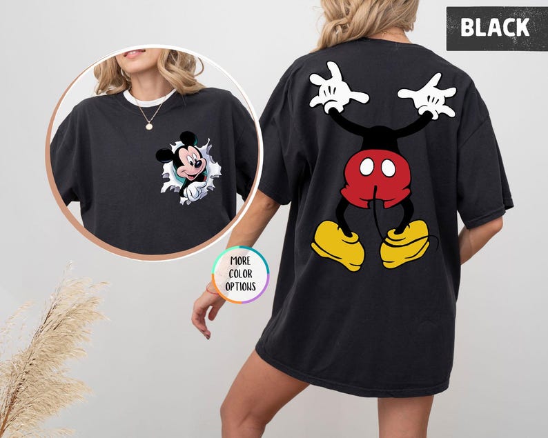 May include: Black t-shirt with a Mickey Mouse design. The front has Mickey emerging from a torn hole, and the back features a full cartoon image of Mickey Mouse with raised arms. The word "BLACK" is printed on the top right of the shirt.