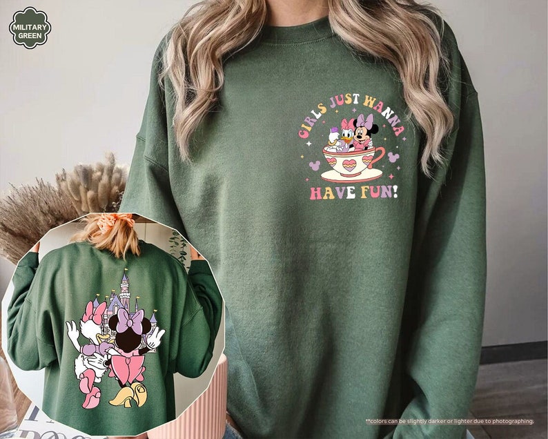 a woman wearing a green sweatshirt with an image of minnie mouse on it