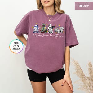 Puede incluir: Camiseta color baya con personajes de Star Wars: R2-D2, Boba Fett, un Stormtrooper y el Halc&oacute;n Milenario. La frase "may the force be with you" est&aacute; escrita debajo de los personajes. La camiseta es de corte holgado.