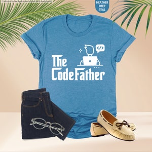 a t - shirt that says the codefather next to a pair of shoes