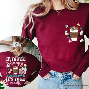 a woman wearing a sweater with a cup of coffee on it