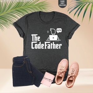 a t - shirt that says the codefather next to a pair of jeans