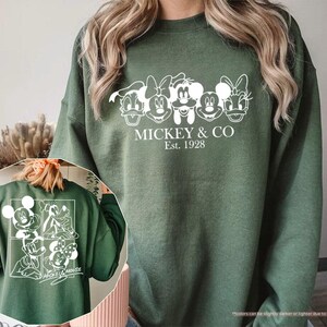 Pu&ograve; includere: Felpa verde militare con grafica bianca di Topolino e amici. Il design frontale include la scritta "MICKEY & CO Est. 1928". Il retro della felpa presenta anche una grafica bianca di Topolino e amici. Una felpa comoda e casual.