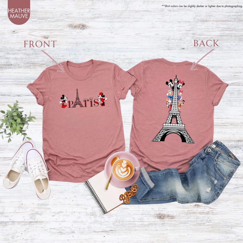 Pu&ograve; includere: T-shirt malva con grafica della Torre Eiffel e la scritta "Paris". La parte anteriore della maglietta presenta la Torre Eiffel con Topolino e Minnie. Il retro della maglietta presenta la Torre Eiffel con vari personaggi dei cartoni animati.