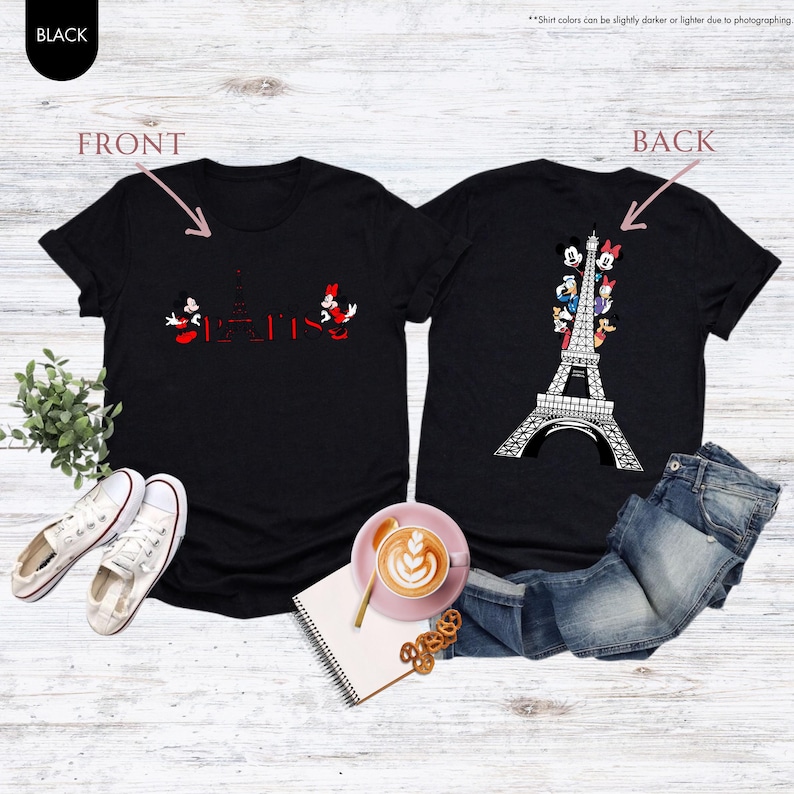 Pu&ograve; includere: T-shirt nere con disegni fronte-retro. Il davanti presenta Topolino e Minnie Mouse con la scritta "Parigi" e la Torre Eiffel in rosso. Il retro mostra la Torre Eiffel con vari personaggi dei cartoni animati.
