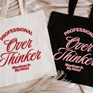 Pu&ograve; includere: Due borse tote, una color crema e una nera, con la scritta "PROFESSIONAL Over Thinker Meetings In My Head". La borsa color crema ha il testo rosso, mentre la borsa nera ha il testo rosa. Entrambe le borse hanno manici abbinati.