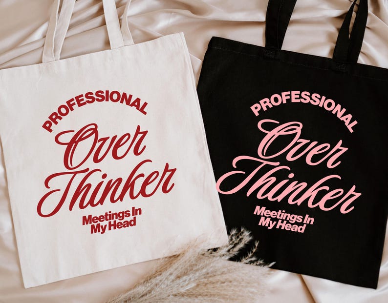 Pu&ograve; includere: Due borse tote, una color crema e una nera, con la scritta "PROFESSIONAL Over Thinker Meetings In My Head". La borsa color crema ha il testo rosso, mentre la borsa nera ha il testo rosa. Entrambe le borse hanno manici abbinati.